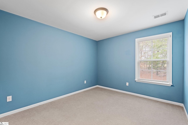 carpeted empty room with baseboards and visible vents