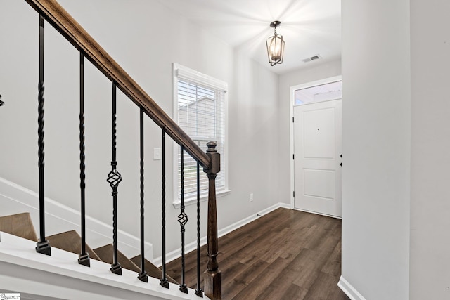 foyer with baseboards, visible vents, stairway, and dark wood finished floors