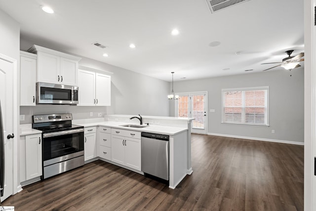 kitchen featuring light countertops, a sink, visible vents, a peninsula, and appliances with stainless steel finishes