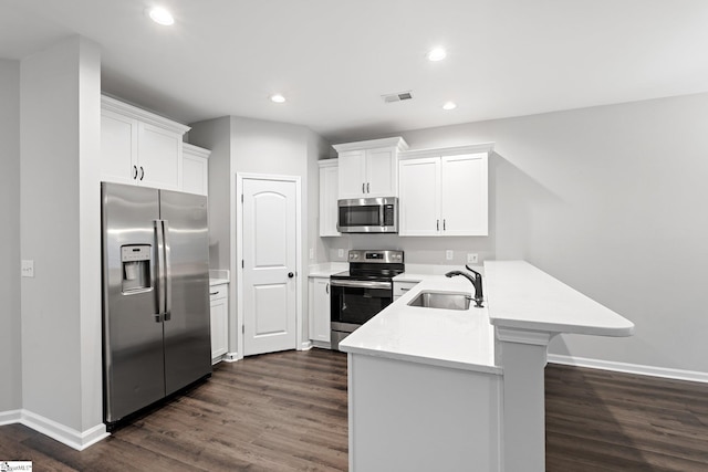 kitchen with light countertops, visible vents, a peninsula, stainless steel appliances, and a sink