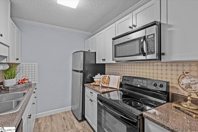 kitchen with white cabinetry, crown molding, light wood-style floors, and appliances with stainless steel finishes