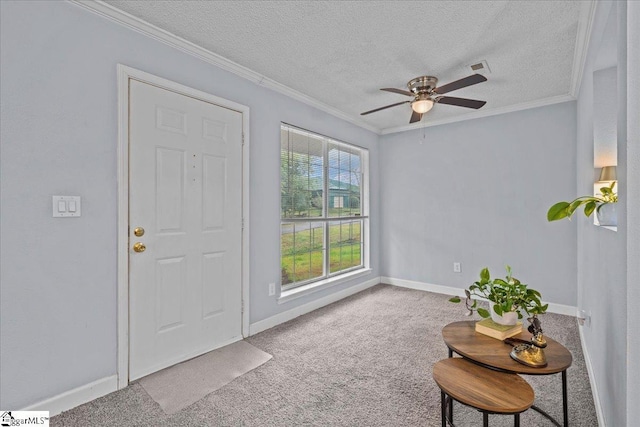 foyer featuring carpet floors, a textured ceiling, a ceiling fan, and crown molding