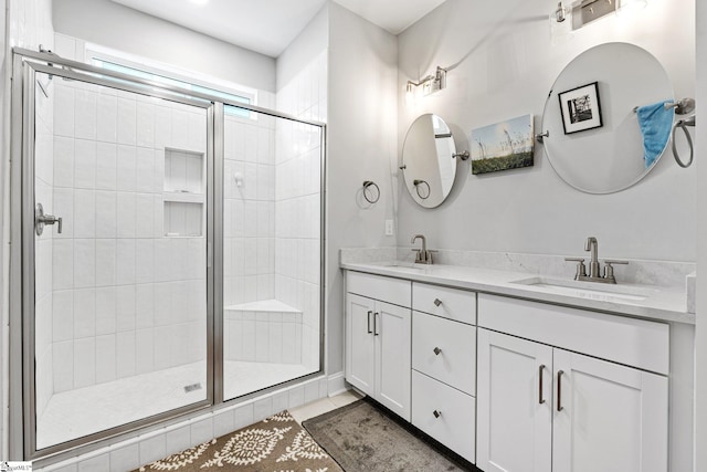 bathroom featuring double vanity, a sink, a stall shower, and tile patterned flooring