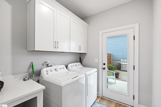 clothes washing area featuring a sink, cabinet space, light wood-style flooring, and independent washer and dryer