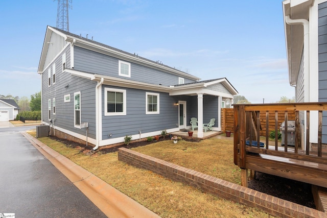 back of house featuring cooling unit and a lawn