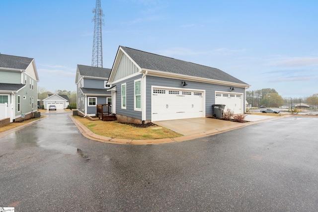 view of side of property featuring board and batten siding, concrete driveway, and roof with shingles