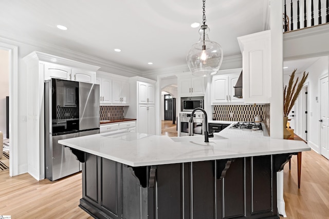 3 Bailey Knoll Ct, Simpsonville, SC 29681 - kitchen with crown molding, a peninsula, stainless steel appliances, arched walkways, and a sink