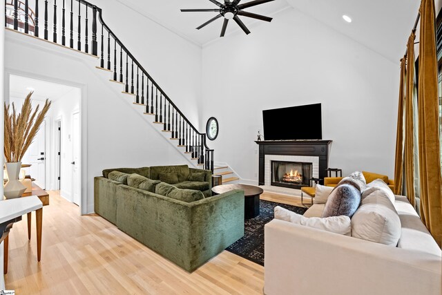 3 Bailey Knoll Ct, Simpsonville, SC 29681 - living area with a brick fireplace, light wood finished floors, stairs, a ceiling fan, and a high ceiling