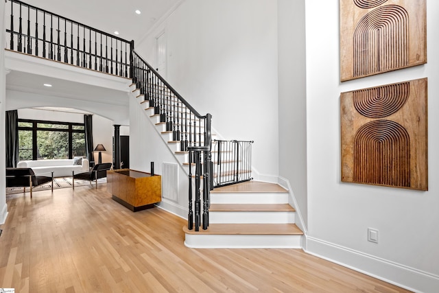 3 Bailey Knoll Ct, Simpsonville, SC 29681 - staircase featuring baseboards, ornate columns, a towering ceiling, wood finished floors, and arched walkways
