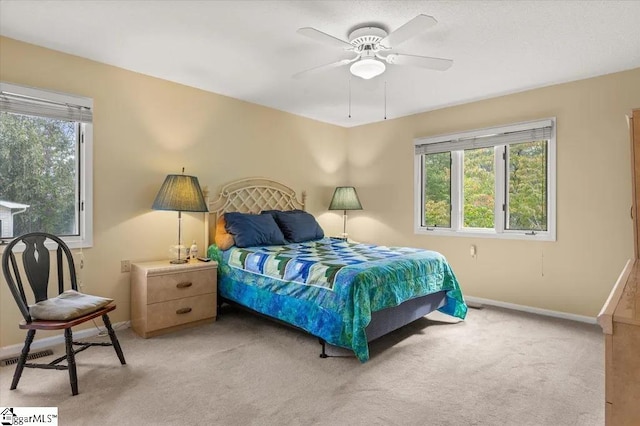 bedroom featuring light carpet, baseboards, visible vents, and a ceiling fan