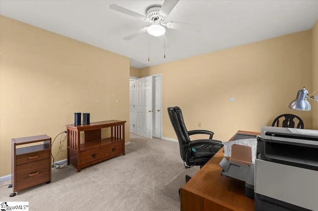 office area featuring light carpet, baseboards, and ceiling fan