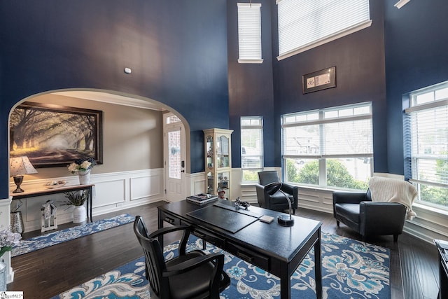 313 Rosendale Way, Simpsonville, SC 29681 - home office featuring arched walkways, a high ceiling, a decorative wall, a wainscoted wall, and hardwood / wood-style floors