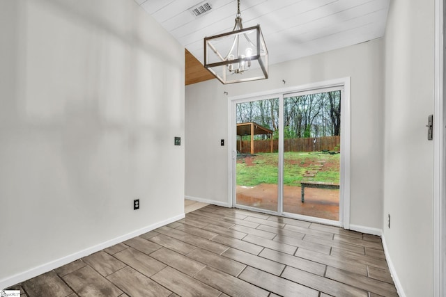 unfurnished dining area featuring visible vents, a chandelier, baseboards, wood finish floors, and lofted ceiling