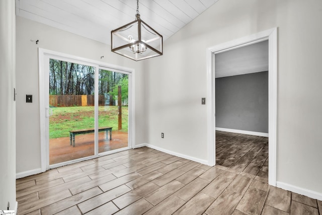 unfurnished dining area with vaulted ceiling, baseboards, a chandelier, and wood tiled floor