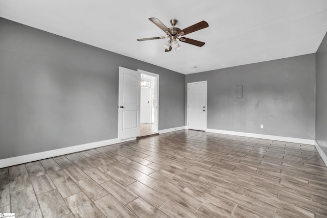 spare room featuring baseboards, wood finished floors, and ceiling fan