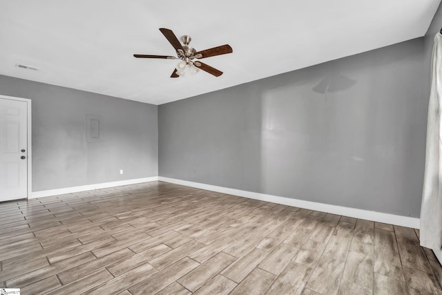 spare room with baseboards, ceiling fan, visible vents, and wood finished floors