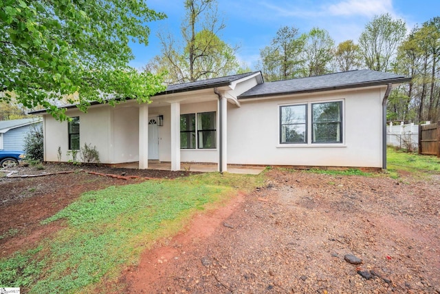 single story home featuring stucco siding and fence