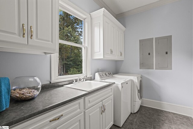 washroom featuring a sink, washing machine and clothes dryer, baseboards, cabinet space, and ornamental molding