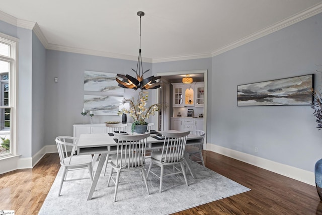 dining room featuring baseboards, wood finished floors, and a healthy amount of sunlight