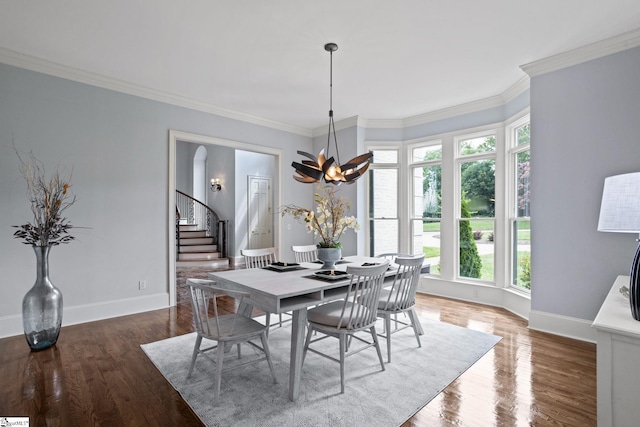 dining area featuring ornamental molding, stairway, and wood finished floors