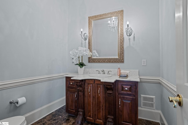 bathroom featuring a wainscoted wall, vanity, toilet, and visible vents