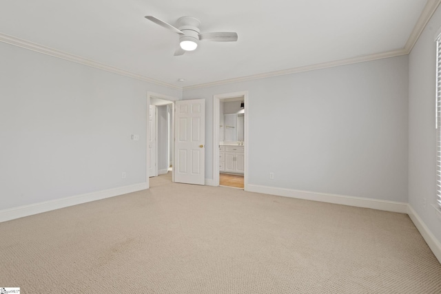 spare room featuring baseboards, ceiling fan, crown molding, and light colored carpet