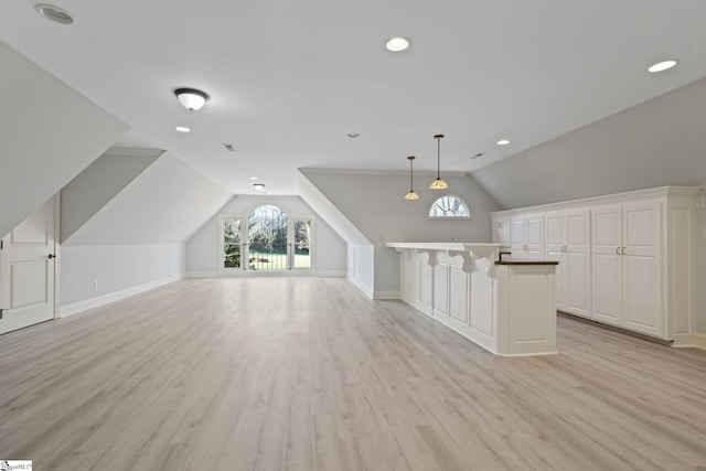 bonus room featuring light wood finished floors, a wealth of natural light, and lofted ceiling