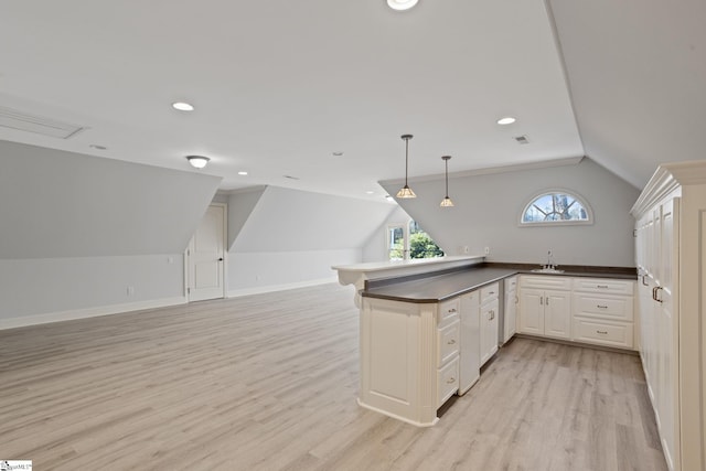 kitchen with light wood-style flooring, dark countertops, a peninsula, and open floor plan