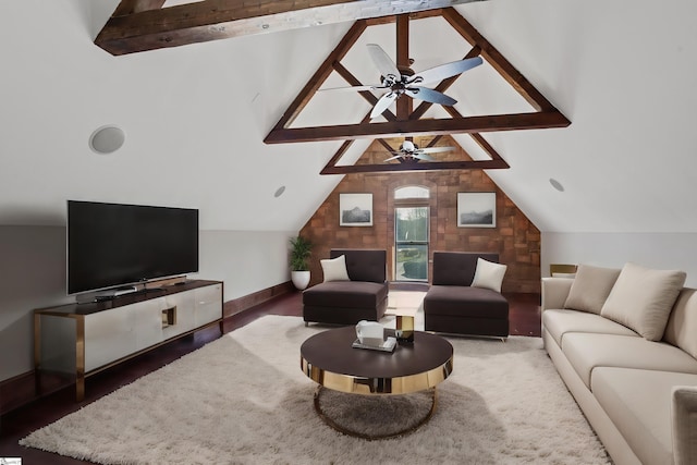 living area with lofted ceiling with beams, baseboards, a ceiling fan, and wood finished floors