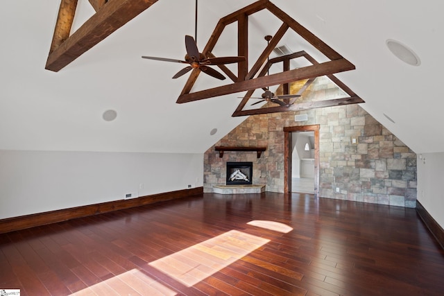 unfurnished living room with wood-type flooring, lofted ceiling with beams, baseboards, a ceiling fan, and a fireplace