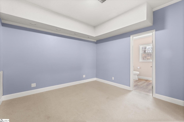 unfurnished bedroom featuring baseboards, ensuite bathroom, and carpet