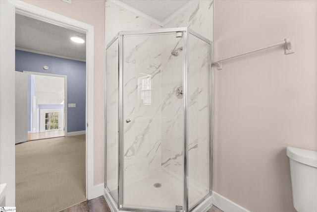 full bathroom with a textured ceiling, ornamental molding, a marble finish shower, and toilet