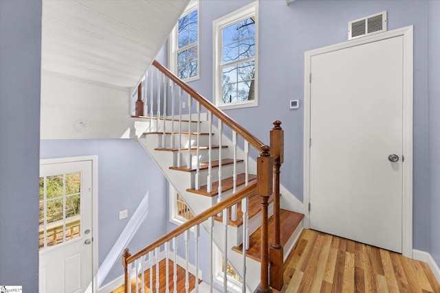 entryway featuring wood finished floors, baseboards, stairs, and visible vents