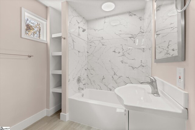 bathroom featuring bathtub / shower combination, baseboards, and wood finished floors