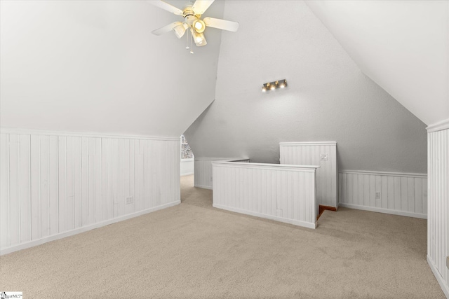 bonus room with wainscoting, carpet, lofted ceiling, and ceiling fan