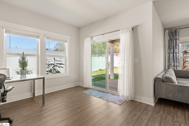 doorway with baseboards and wood finished floors