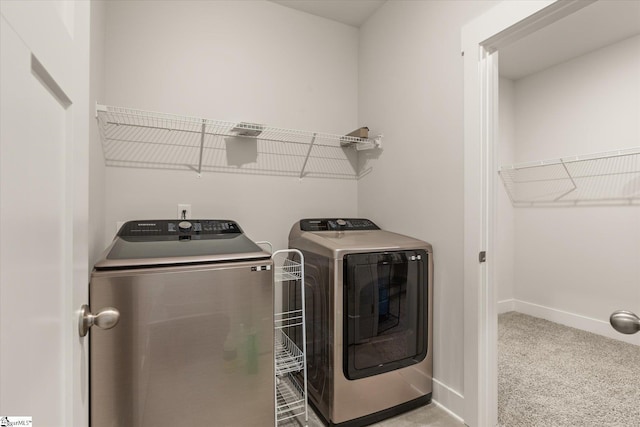 laundry area featuring carpet floors, washer and clothes dryer, and baseboards