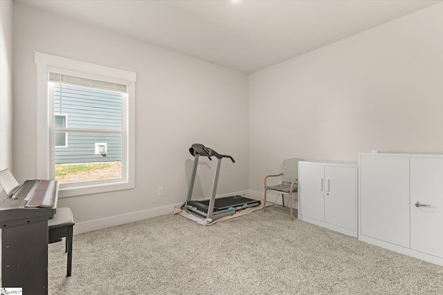 workout room featuring baseboards and carpet floors