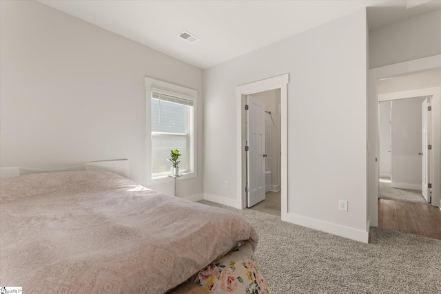 carpeted bedroom with baseboards and visible vents
