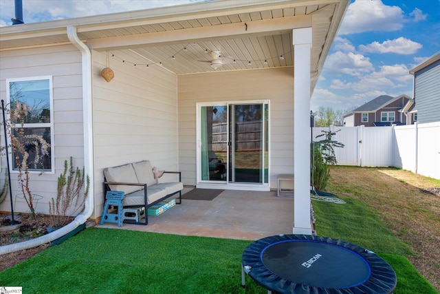 view of patio with outdoor lounge area, ceiling fan, fence, and a trampoline