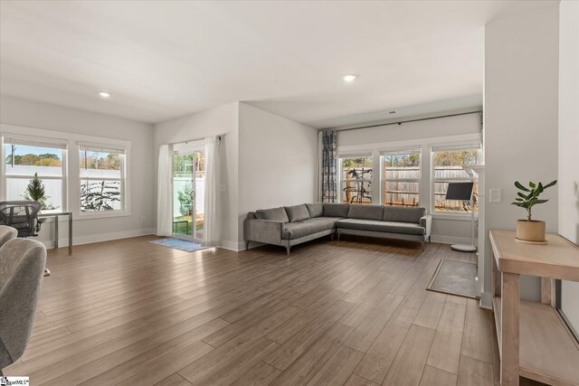 living area featuring baseboards, light wood-style floors, and recessed lighting