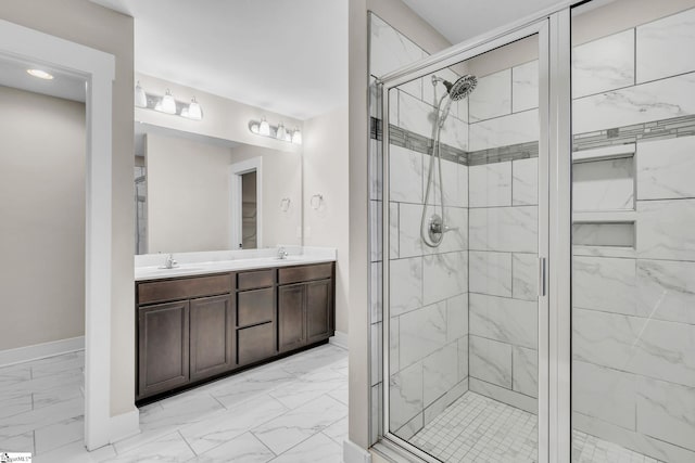 full bathroom featuring marble finish floor, a sink, double vanity, and a shower stall