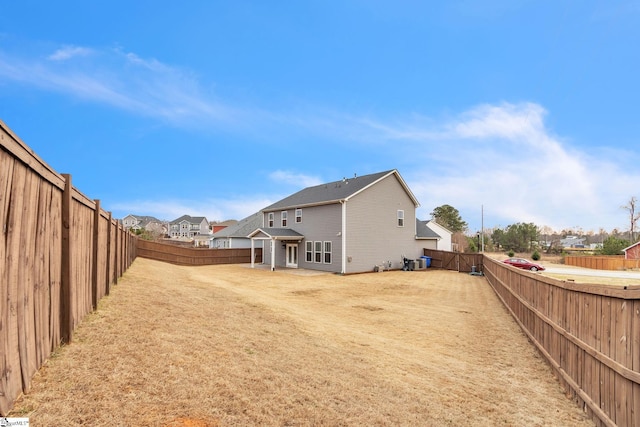 back of property with a lawn, a fenced backyard, and a residential view