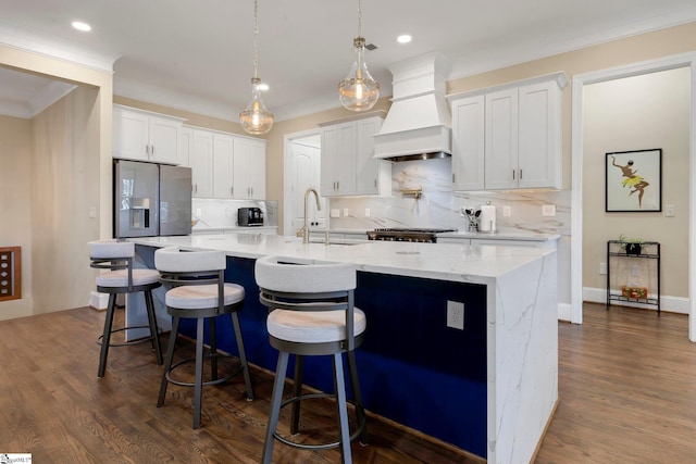 9 Graywood Ct, Simpsonville, SC 29680 - kitchen featuring dark wood-style floors, a kitchen island with sink, refrigerator with ice dispenser, and premium range hood