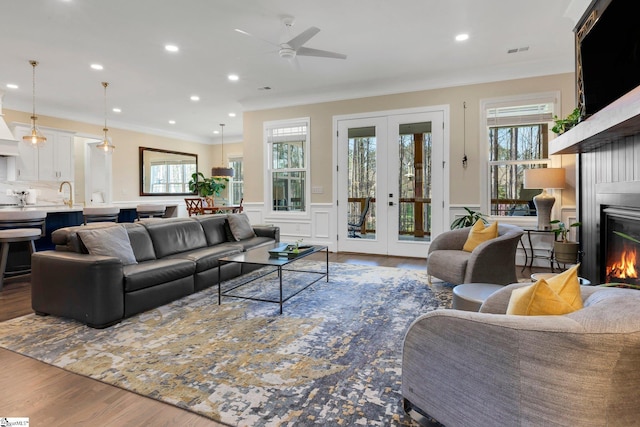 9 Graywood Ct, Simpsonville, SC 29680 - living area with a wainscoted wall, wood finished floors, a glass covered fireplace, visible vents, and ceiling fan