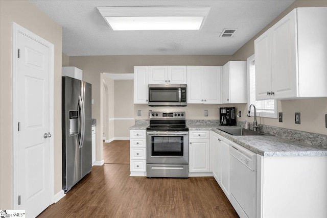 kitchen with white cabinetry, visible vents, a sink, and stainless steel appliances