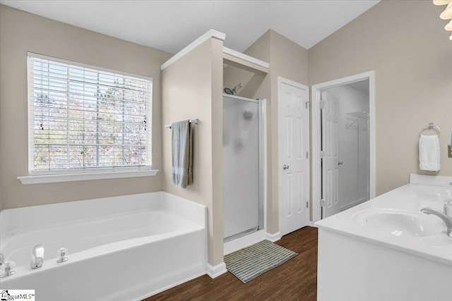 bathroom with wood finished floors, a sink, a garden tub, and a shower stall