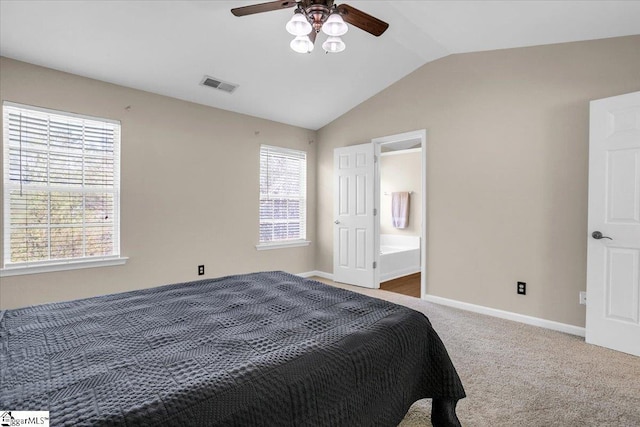 carpeted bedroom with vaulted ceiling, ensuite bathroom, baseboards, visible vents, and ceiling fan