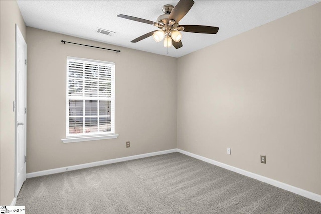 carpeted spare room featuring baseboards, visible vents, ceiling fan, and a textured ceiling