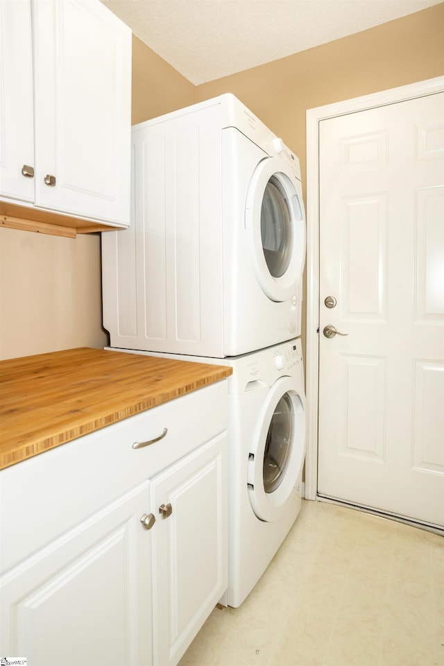 213 Lexington Place Way, Greenville, SC 29615 - washroom with cabinet space, stacked washer / dryer, and light floors